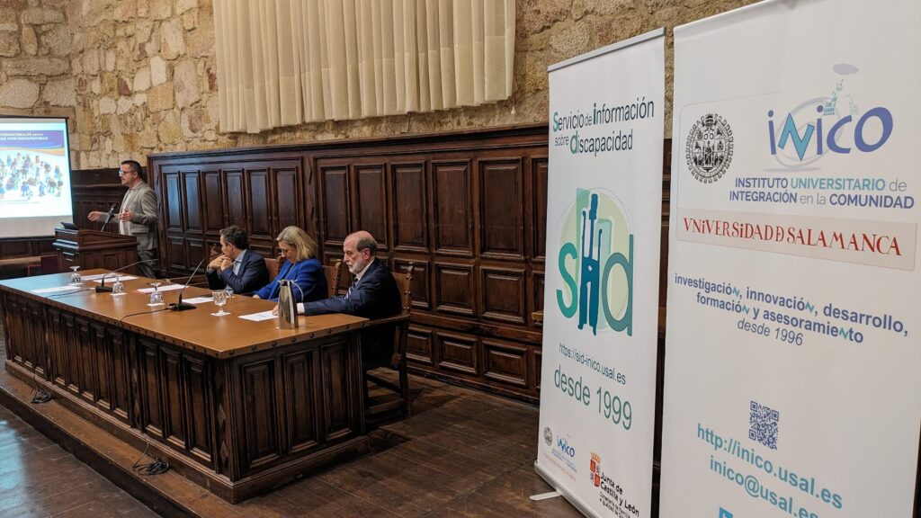 Acto en la universidad de Salamanca. Varias personas en una mesa y carteles del INICO y el SID. Foto: David Aparicio