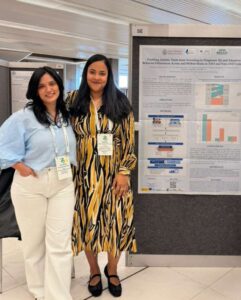 Clara Fernández Álvarez y Jo Ann Yon Hernández junto a un póster