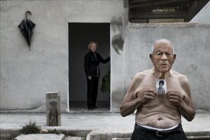 hombre mayor con alzheimer sujeta una foto en blanco y negro